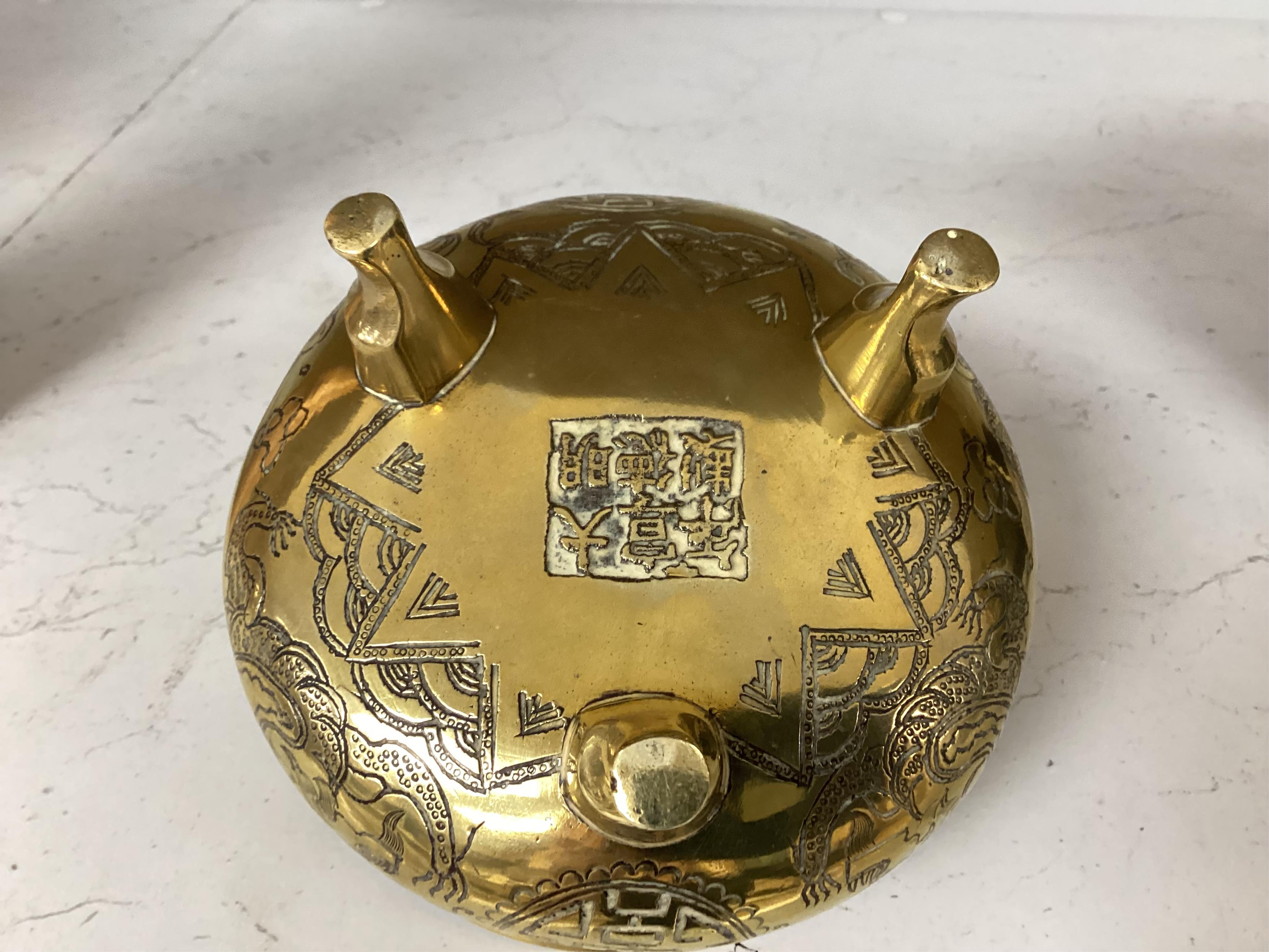 A Chinese engraved and chased bronze tripod censer, Xuande mark, early 20th century, 10.5cm. Condition - good